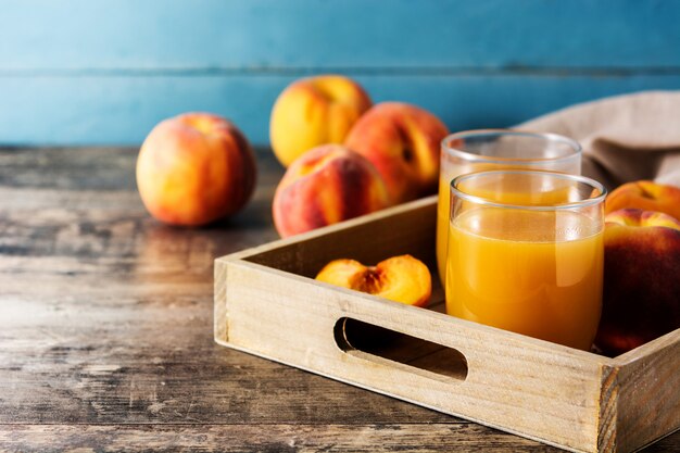 Jus de pêche naturel en verre sur table en bois