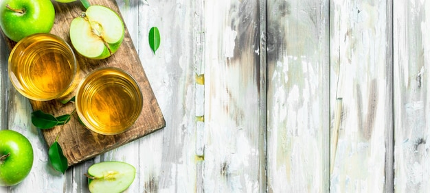 Jus de pomme dans une tasse de verre sur une planche de bois