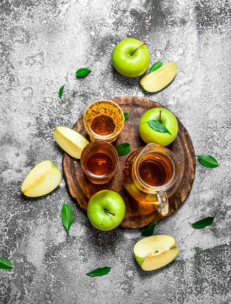 Jus de pomme en pichet sur le plateau avec une pomme verte fraîche