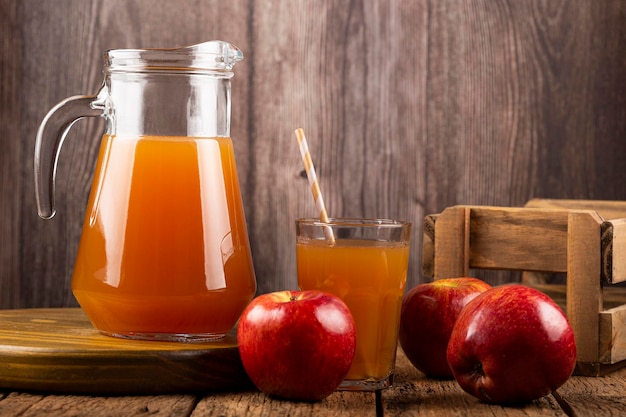 Jus de pomme et pommes rouges sur la table.