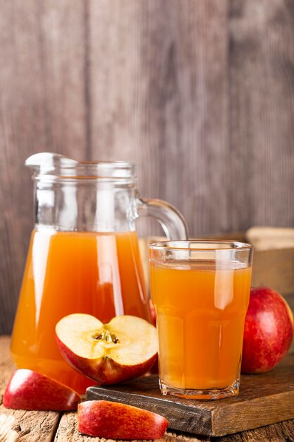 Jus de pomme et pommes rouges sur la table.