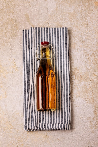 Jus de pomme rouge dans une bouteille sur une serviette sur fond de béton Mise au point sélective Vue de dessus