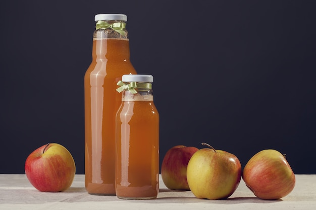 Jus de pomme utile avec des pommes autour d'une table en bois