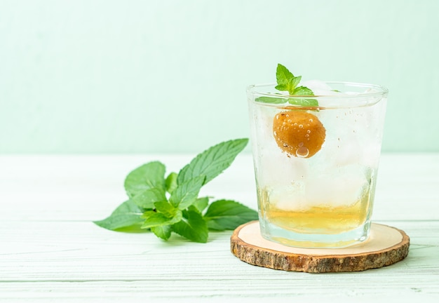 Jus de prune glacé avec soda et menthe poivrée sur table en bois - boisson rafraîchissante