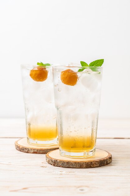 Jus de prune glacé avec soda et menthe poivrée sur table en bois - boisson rafraîchissante