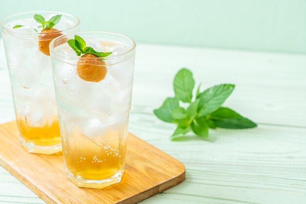 Jus de prune glacé avec soda et menthe poivrée sur table en bois - boisson rafraîchissante