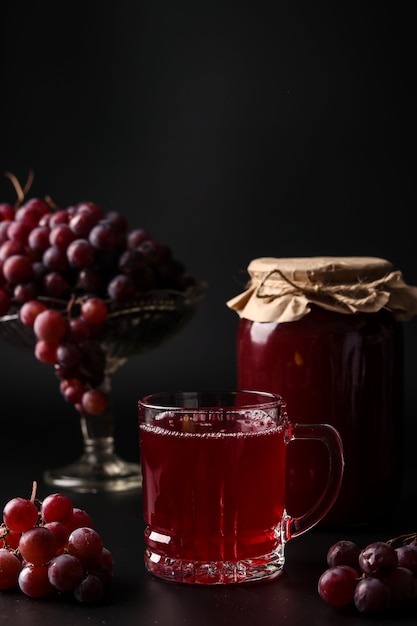 Jus de raisin dans un verre et des canettes, cuit dans un presse-agrumes, récolte du jus d'une vendange
