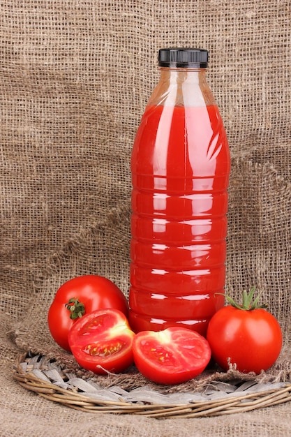 Jus de tomate en bouteille sur fond d'un sac