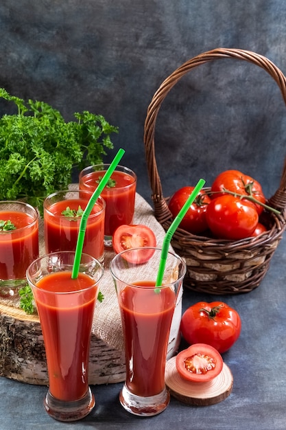 Le jus de tomate dans des verres se dresse sur une souche en bois