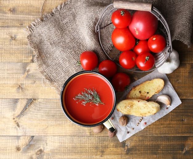 Jus de tomate fait maison dans des toasts de tasse de couleur et des tomates fraîches sur fond de bois