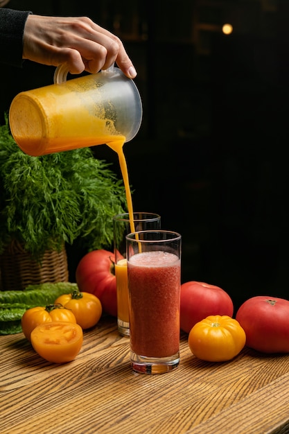 Photo jus de tomate sur une table près des tomates vertes et jaunes et rouges