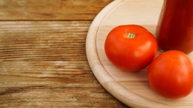 Jus de tomate, tomates fraîches sur fond de bois - photo horizontale