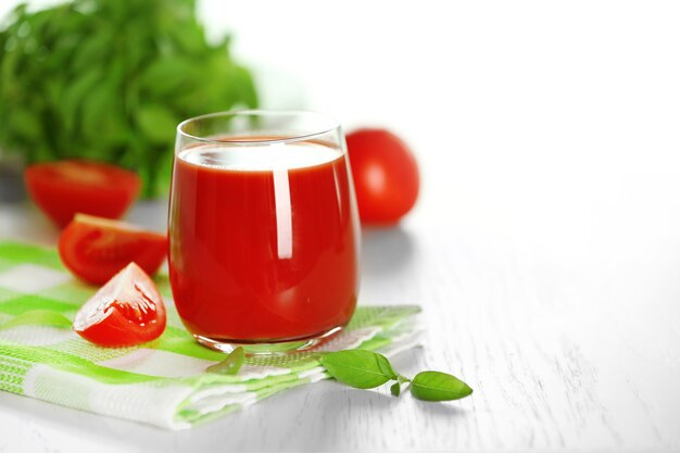 Jus de tomate et tomates fraîches sur le plan rapproché de table en bois