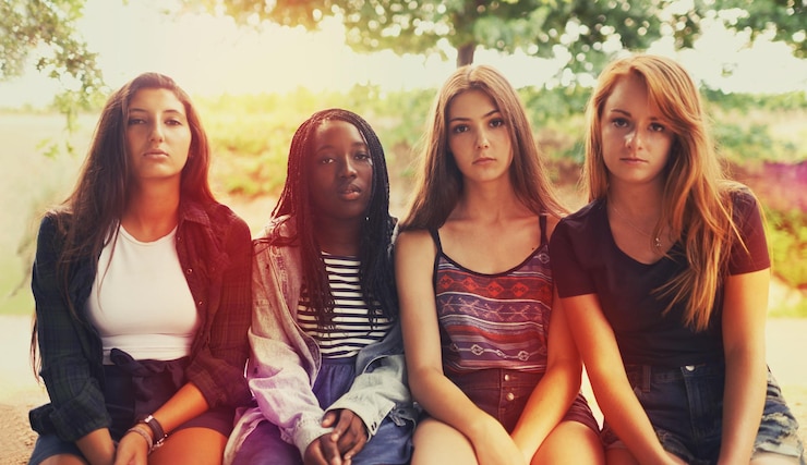 Photo jusqu'à présent, ils n'étaient pas si amusés un groupe d'adolescentes mécontentes assises à l'extérieur
