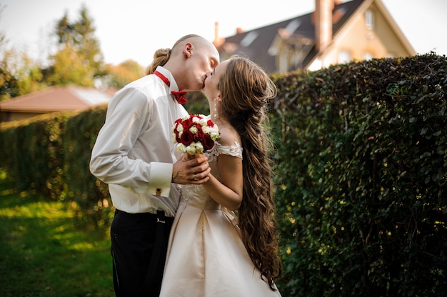 Photo juste marié heureux homme et femme s'embrassant dans le parc verdoyant. conception du mariage