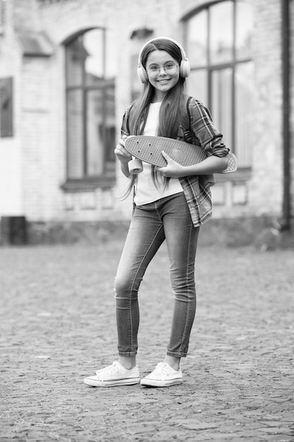 Juste patiner Un enfant heureux tient une planche à sous à l'extérieur Faire de la planche à roulettes Amusement Croiseur et transport Extrême et adrénaline Sport et loisirs Passe-temps actif Vacances d'été Restez calme et patinez