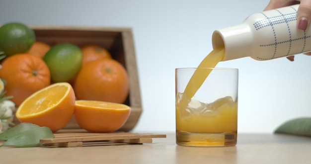 Juste pressé du jus d'orange frais versé dans le verre pour prendre le petit déjeuner