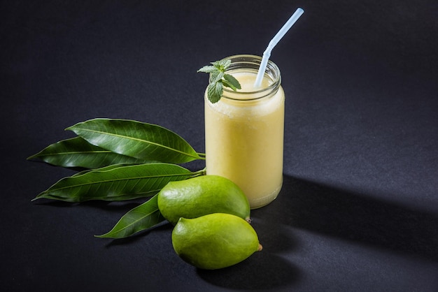 Kairi Panha OR Panna OR Raw Mango Drink est une boisson d'été indienne traditionnelle et la plus populaire servie dans un verre sur un fond coloré ou en bois. Mise au point sélective