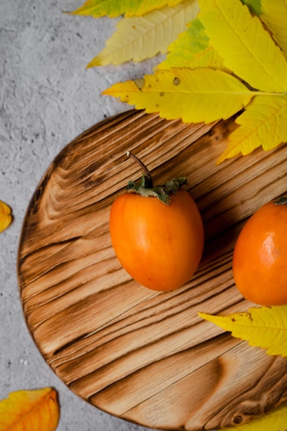 kaki sur un plateau en bois, espace pour le texte, vue de dessus, fruits d'automne