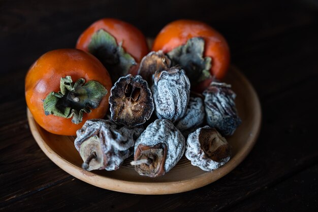 Kaki séché et kaki frais sur fond de bois Alimentation saine Alimentation saine