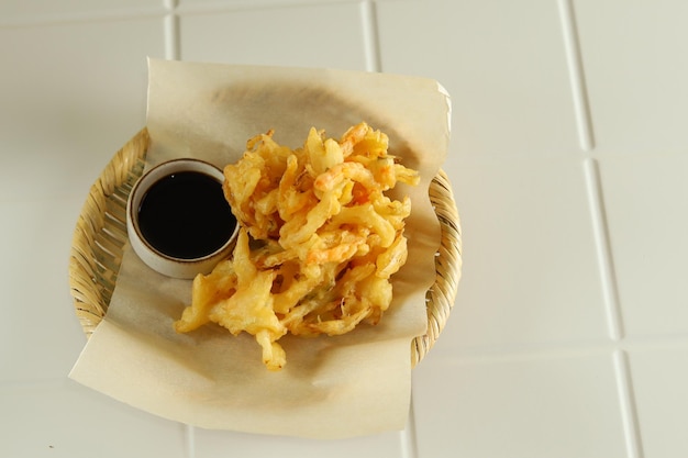 Kakiage tempura, légumes frits servis dans une assiette blanche.