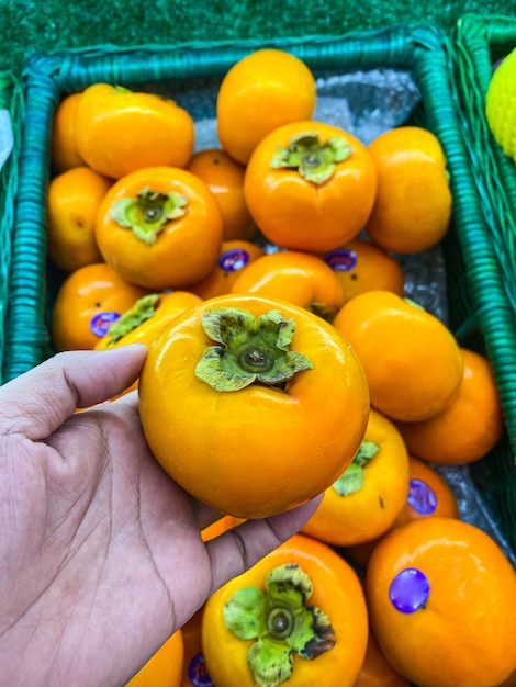 Kakis mûrs dans des paniers en osier au marché