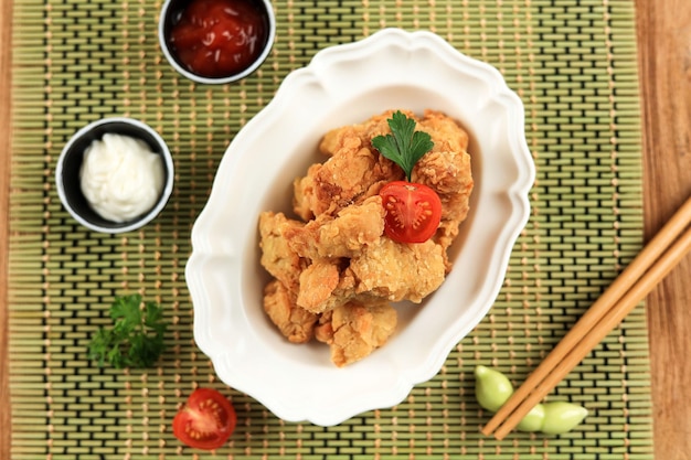Karaage de poulet sur bol blanc avec tomate et persil vue de dessus cuisine japonaise