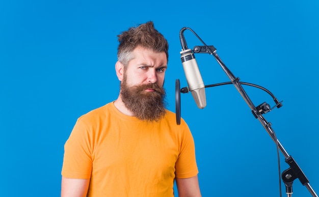 Karaoké. Homme chantant avec microphone. Enregistrements en studio. Un homme barbu chante au micro. Microphone. Chante une chanson. Chanter en studio.