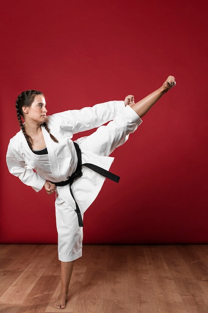 Karaté Femme En Kimono Blanc Traditionnel Sur Fond Rouge