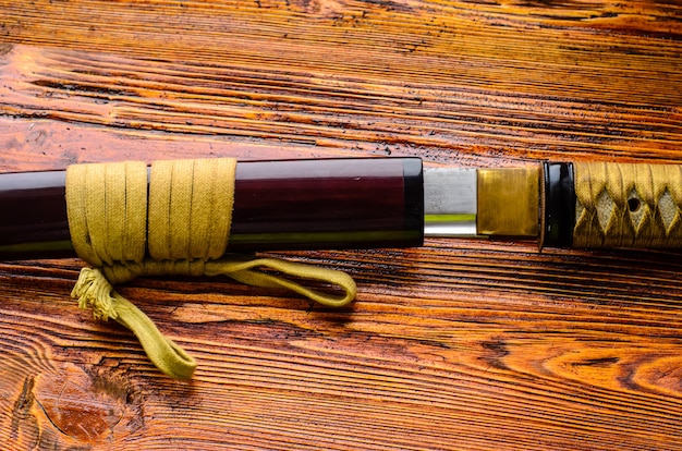 Katana d'épée japonaise sur un fond en bois