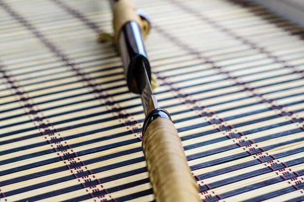 Katana épée japonaise sur tapis de bambou mise au point sélective