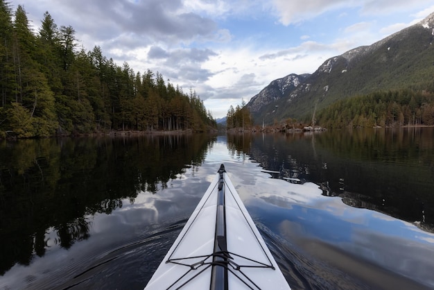 Photo kayak dans les eaux calmes avec le paysage de montagne canadien arrière-plan lac buntzen à vancouver colombie-britannique canada