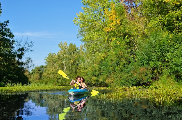 Kayak en famille, mère et fille pagayant en kayak sur une excursion en canoë de rivière s'amusant, week-end actif et vacances avec enfants, concept de remise en forme