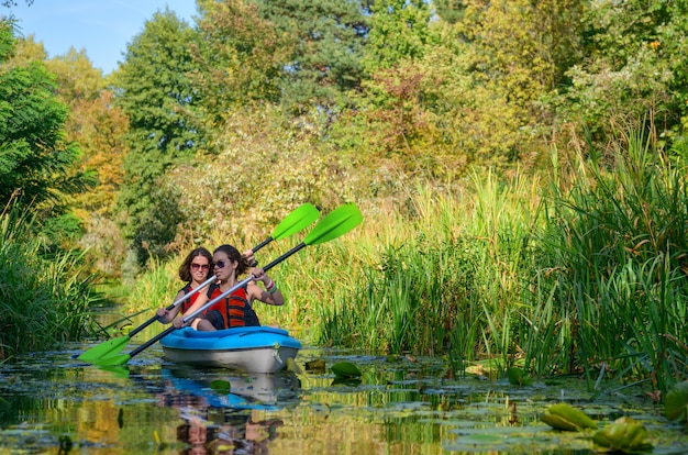 Kayak en famille, mère et fille pagayant en kayak sur la rivière en canoë, s'amuser, week-end d'automne actif et vacances avec enfants, concept de remise en forme