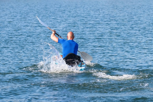 Kayak de pagaie de jeune kayakiste. Sportif kayak Blue Water.