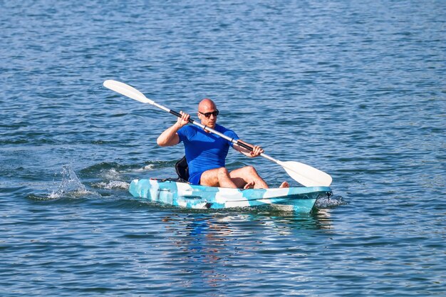 Kayak de pagaie de jeune kayakiste. Sportif kayak Blue Water.