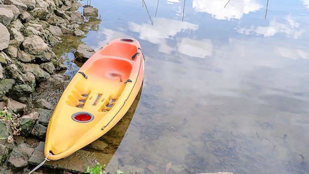 Kayaks garés dans la rivière et reflet des nuages dans l'eau.