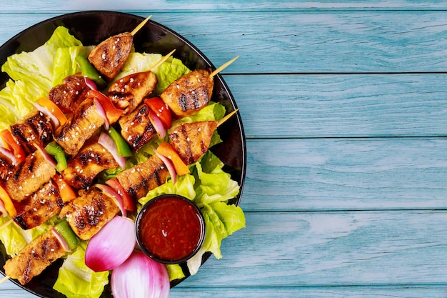 Kebab sur bâton en bois avec salade fraîche.