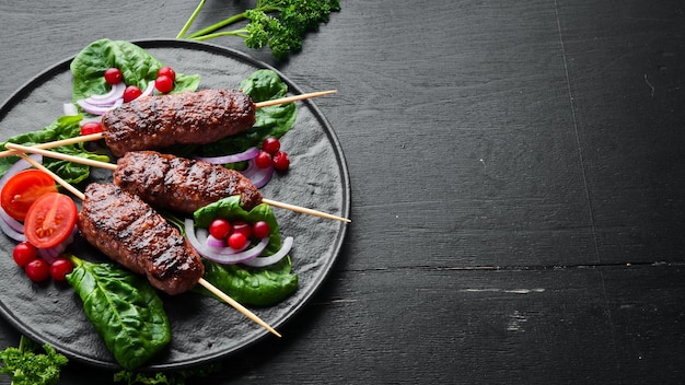 Kebab Brochette de viande arabe ou méditerranéenne traditionnelle du Moyen-Orient avec légumes et herbes Vue de dessus Espace libre pour votre texte