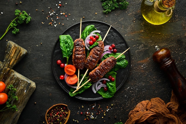 Kebab Brochette de viande arabe ou méditerranéenne traditionnelle du Moyen-Orient avec légumes et herbes Vue de dessus Espace libre pour votre texte