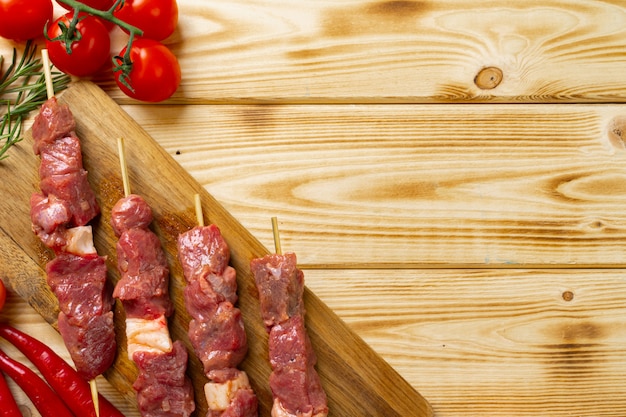 Kebab cru de viande sur bois avec légumes.