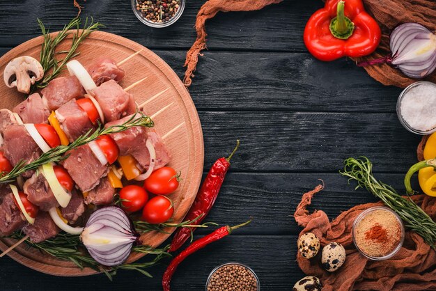 Kebab cru de viande sur un fond en bois avec des légumes Vue de dessus Espace libre pour le texte