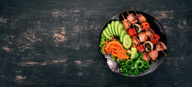 Kebab de veau cuit au four sur une assiette avec des légumes frais Sur un fond en bois Vue de dessus Espace de copie