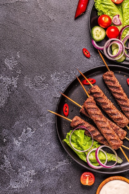 Kebab de viande traditionnel moyen-oriental, arabe ou méditerranéen avec légumes et pain pita. Vue de dessus.