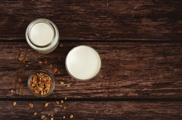 Kéfir de produit laitier fermenté dans un bocal en verre avec granola sur fond beige