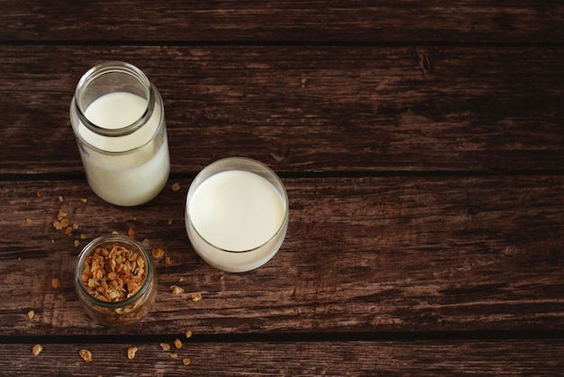 Kéfir de produit laitier fermenté dans un bocal en verre avec granola sur fond beige