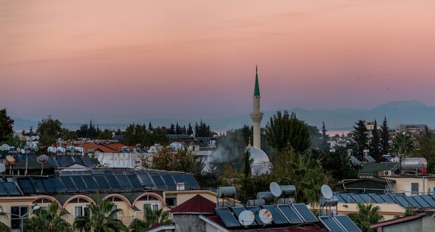 Photo kemer, turquie - vue du soir sur les toits de la ville et coucher de soleil sur les montagnes