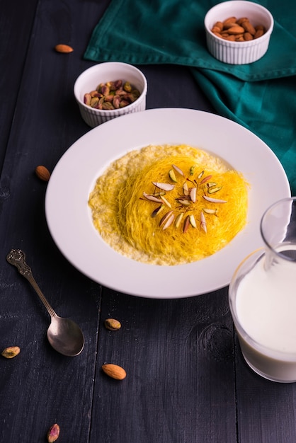 Kesar sutarfeni ou sutar feni ou firni ou seviyan ou laccha sucré indien, râpé, farine de riz floconneux rôti dans du ghee, mélangé avec du sucre fondu pour former une barbe à papa, avec de la pistache et des amandes