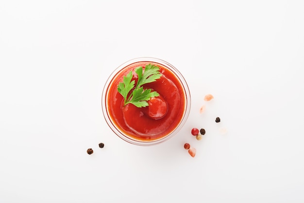 Ketchup aux tomates savoureux dans un bol isolé sur blanc