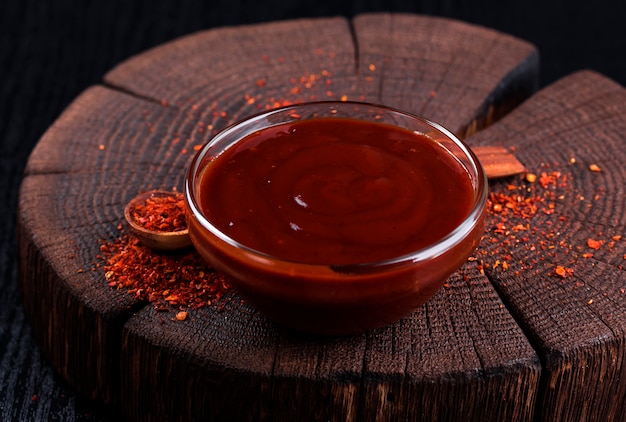 Ketchup dans un bol sur un fond en bois foncé